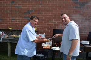 Dan Schmitt (15 years, sales) serves a hotdog to our faithful mailman